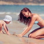 Happy young family.Young beautiful mother and her son having fun on the beach.