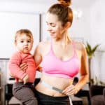 Young mother in sportswear measuring her waist worried about her weight after the child birth