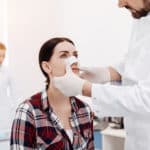 Nice serious woman having a medical dressing on her nose