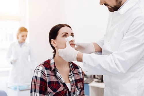 Nice serious woman having a medical dressing on her nose