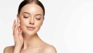 A woman touching her cheek after Restylane® and BOTOX® Cosmetic treatments