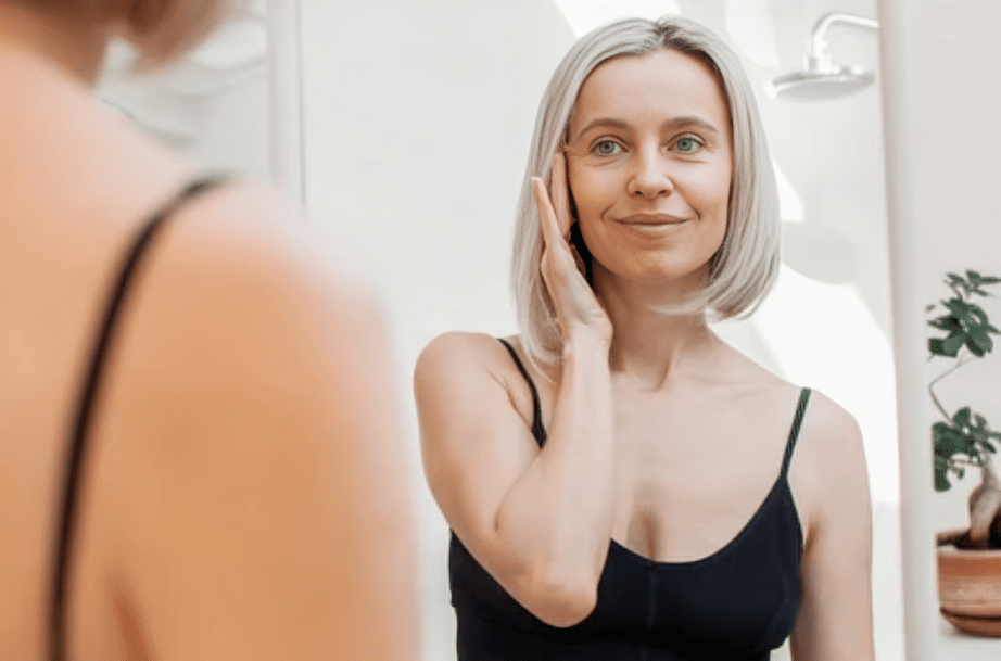 Woman looking in the mirror after XERF skin tightening in Rancho Mirage